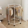 Біла шестикутна кругла складана вішалка на колесах.